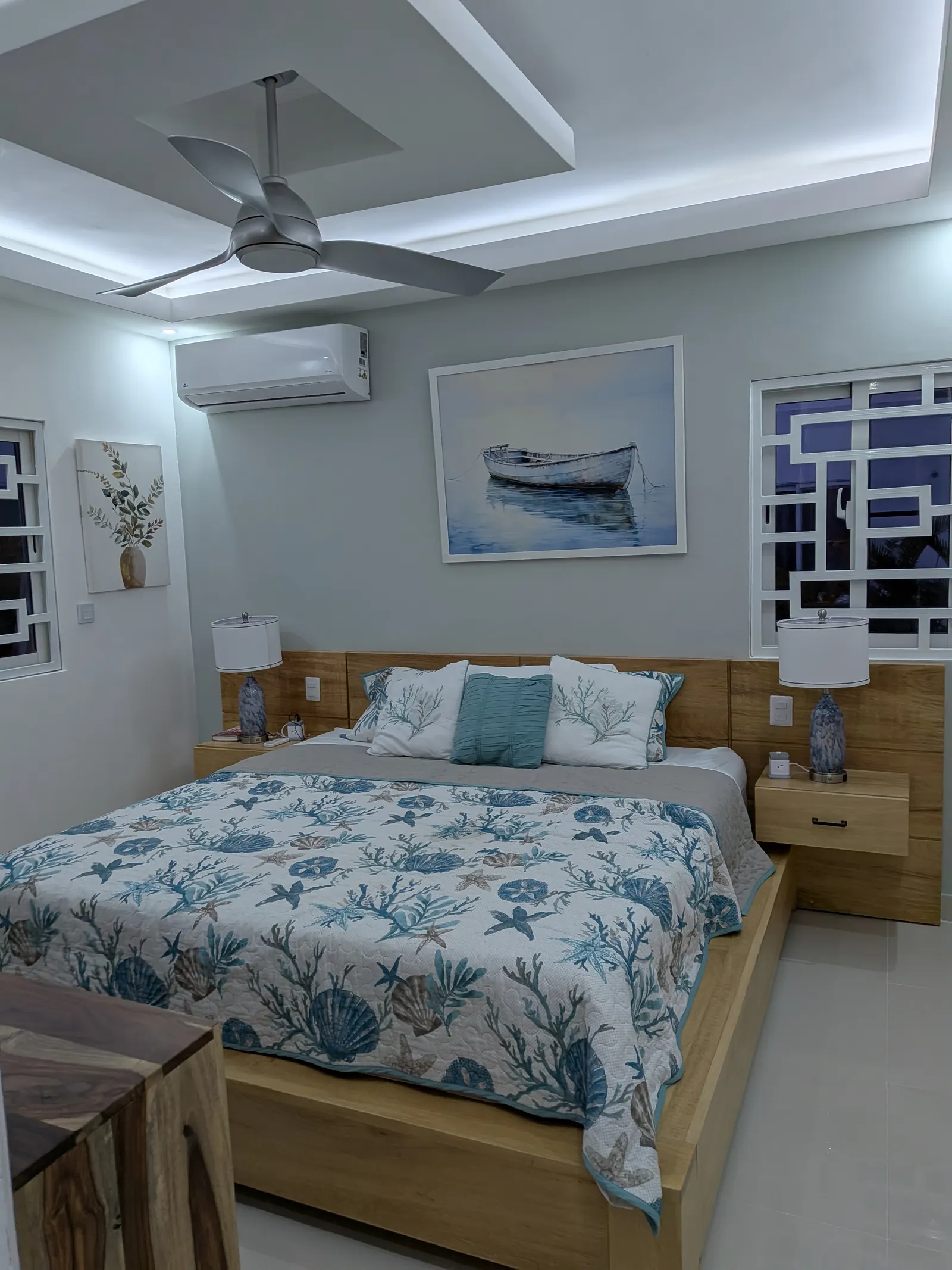 The master bedroom, with a king bed and coastal styling